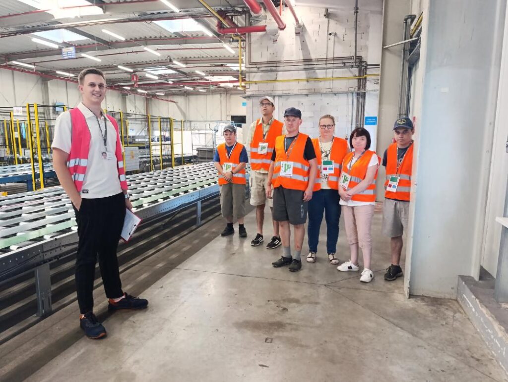 GRUPA PRACOWNIKÓW ZAZ SWOBODA W POMARAŃCZOWYCH KAMIZELKACH W FIRMIE SUN-GARDEN