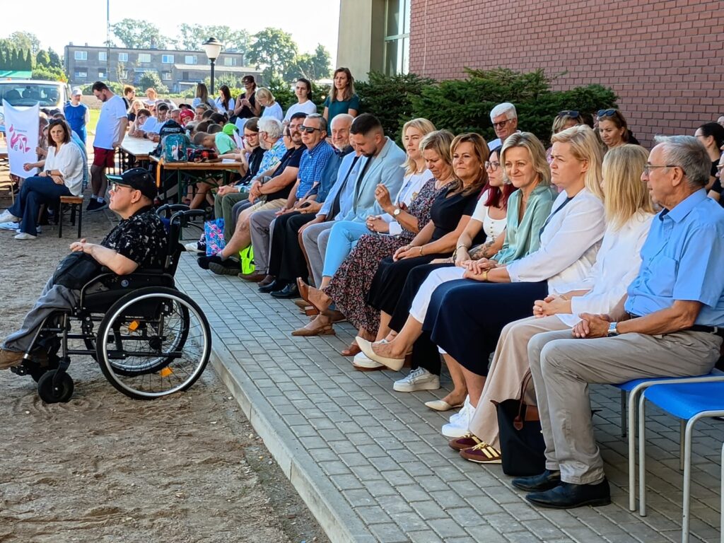 widzowie siedzą na krzesłach. zaproszeni goście oraz osoby niepełnosprawne