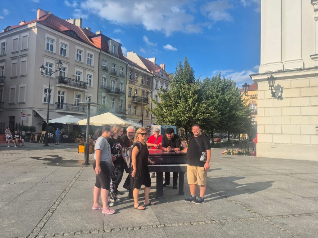 GRUPA NIEMIECKA PRZE RATUSZEM W KALISZU PRZY FORTEPIANIE