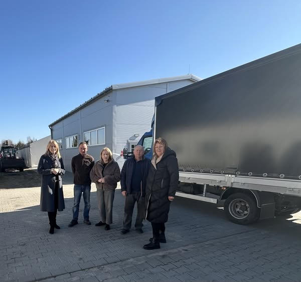 zdjęcie grupowe na tle busa zakładu